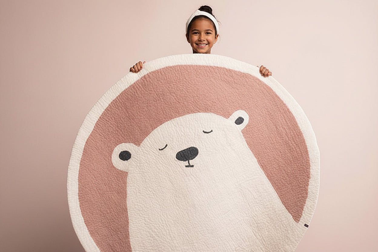 Person holding a round rug with a bear design on a pink background