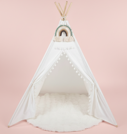 White teepee with a rainbow decoration on a pink background